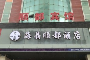 A hotel sign with the name '海晶顺都酒店' and a logo with a circular design and a stylized wave. - Ruisiteyizhi Hotel Rui an Tang Xia Zhong Xin Xi Lu Dian (Rui'an)