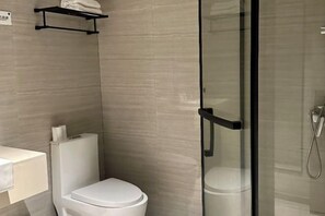 A modern bathroom with a toilet, a glass shower enclosure, and a towel rack. - Ruisiteyizhi Hotel Rui an Tang Xia Zhong Xin Xi Lu Dian (Rui'an)