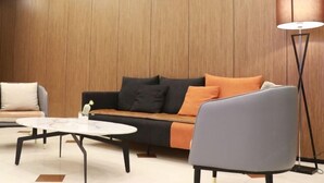 A modern living room with a sofa, a coffee table, and a floor lamp.