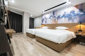 A hotel room with two beds, a cityscape painting, a wooden floor, and a desk with a lamp. - Ruisiteyizhi Hotel Rui an Tang Xia Zhong Xin Xi Lu Dian (Rui'an)