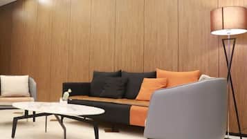 A modern living room with a sofa, armchair, and coffee table.