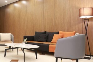 Ein modernes Wohnzimmer mit einer Couch, einem Sessel und einem Couchtisch.