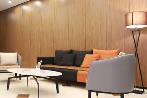 Una sala de estar moderna con un sofá, un sillón y una mesa de centro.