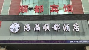 A hotel sign with Chinese characters and a logo.