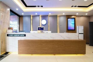 A hotel reception desk with a wooden counter, a digital screen, and a refrigerator. - Ruisiteyizhi Hotel Rui an Tang Xia Zhong Xin Xi Lu Dian (Rui'an)