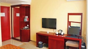 A hotel room with a wooden desk, a television, a computer, a small seating area, and a wardrobe. - Jixi City Guesthouse (Jixi)