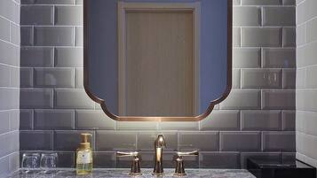 Un bagno con un lavabo in marmo, uno specchio grande e un porta asciugamani.