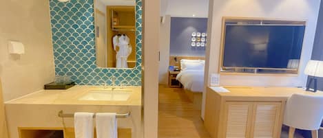 Un baño de hotel con lavamanos, espejo y perchero para toallas.