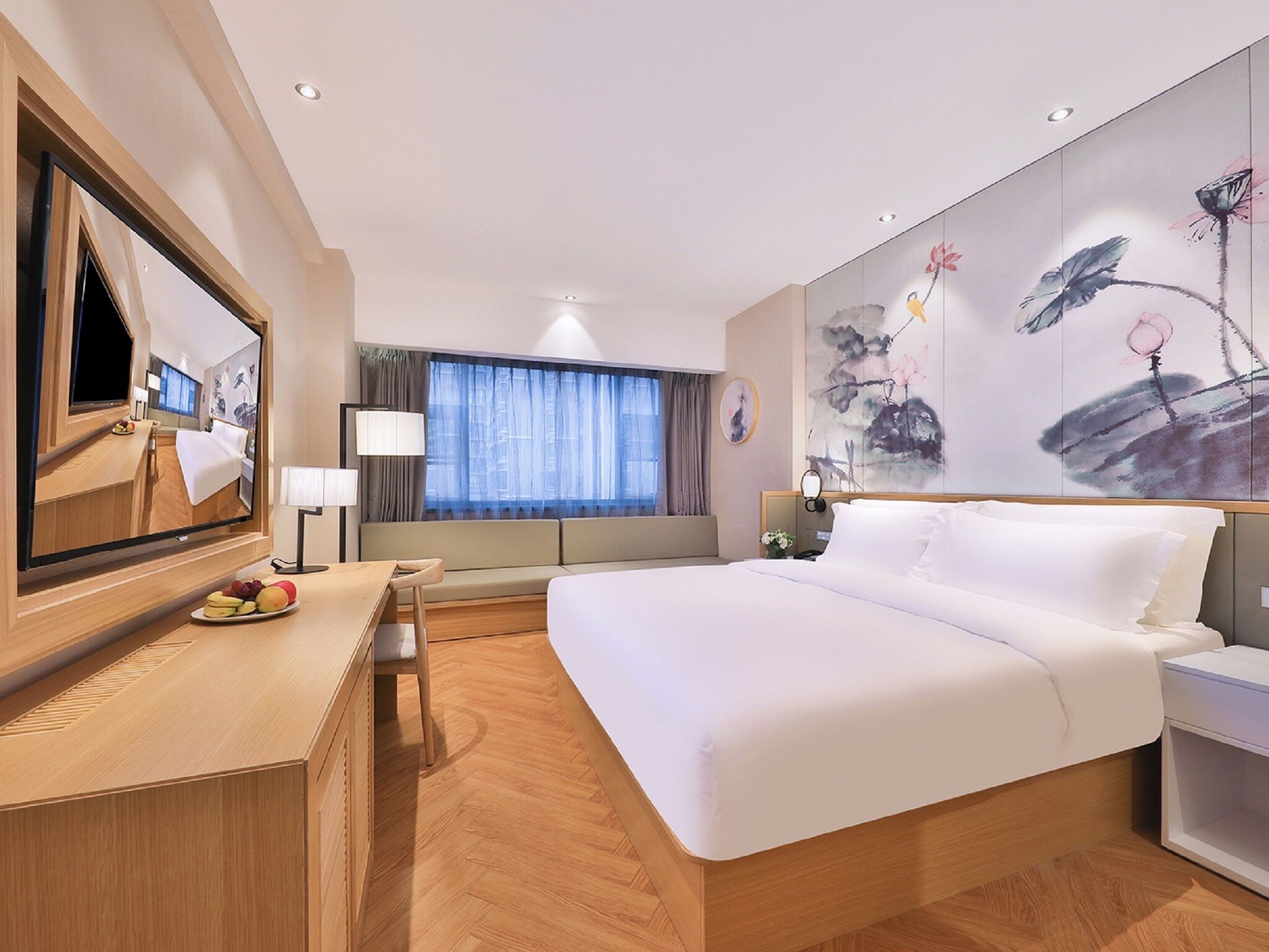 A modern hotel room with a large bed, a desk with a chair, a television, and a large window with curtains.