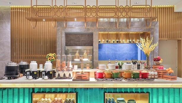 Een buffetopstelling met diverse etenswaren en keukenapparatuur.