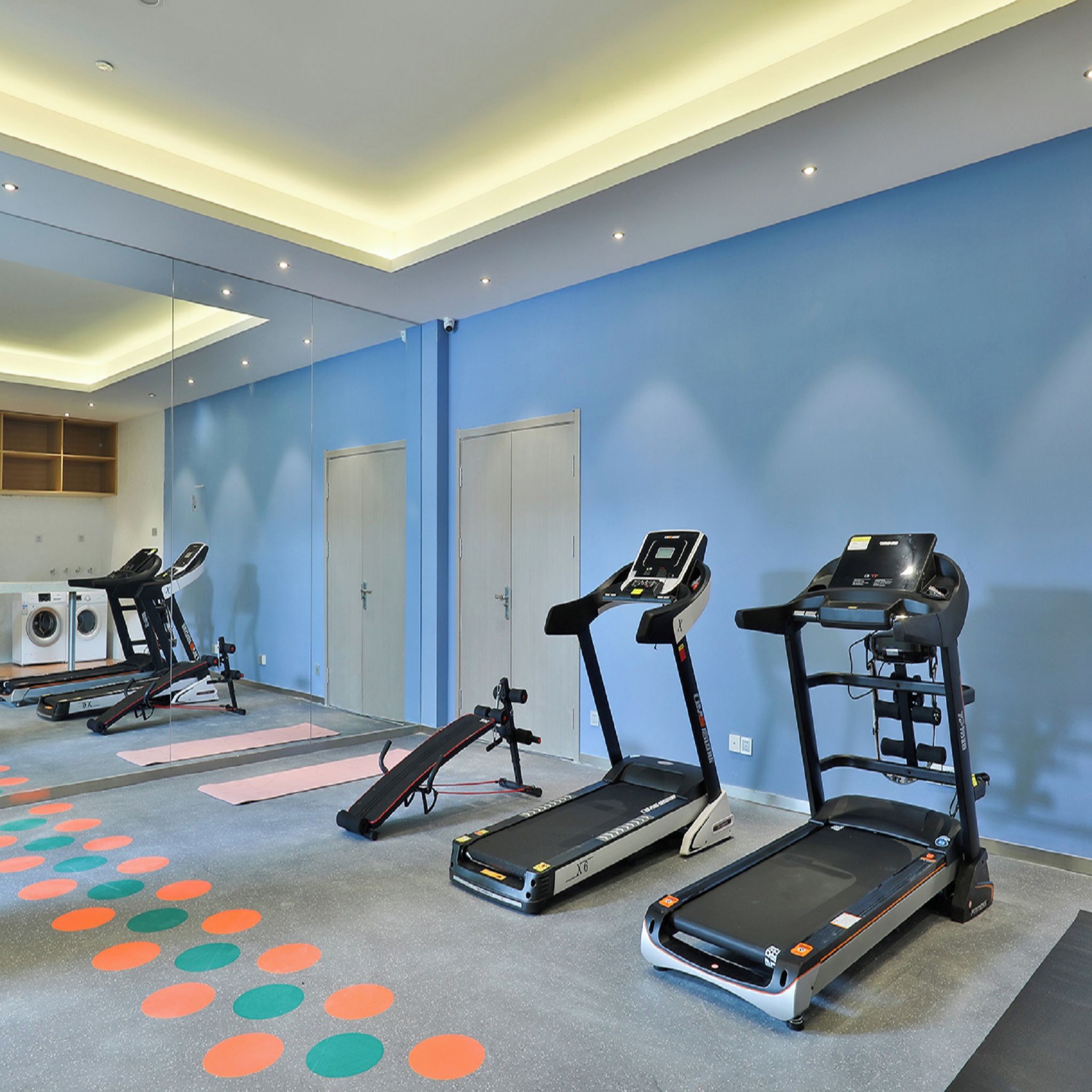 A fitness room with treadmills, a rowing machine, and a stationary bike.