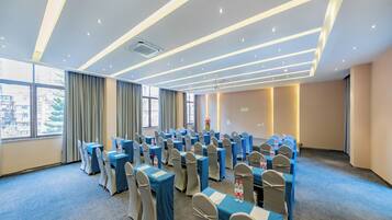A conference room with tables and chairs, large windows, and a modern ceiling design.