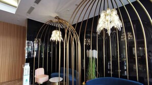 Een modern interieur met een blauwe bank, een ronde tafel en een kroonluchter.