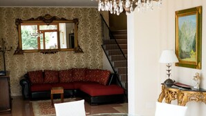 Ein Wohnzimmer mit Glastisch, rotem Sofa und einer Chandelier.