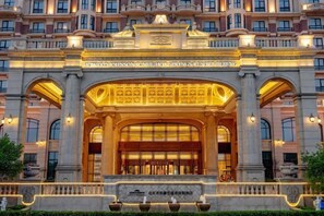 The facade of Howard Johnson Hunke Hot Springs Resort Beijing with classical architecture and illuminated entrance.