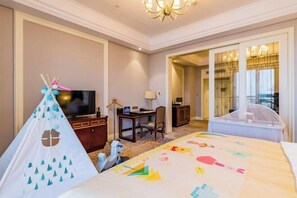 A hotel room with a bed, a television, a desk, and a chair. There is a tent-like structure with a cartoon character on the bed. - Howard Johnson Junhe Hotel Beijing (Beijing)