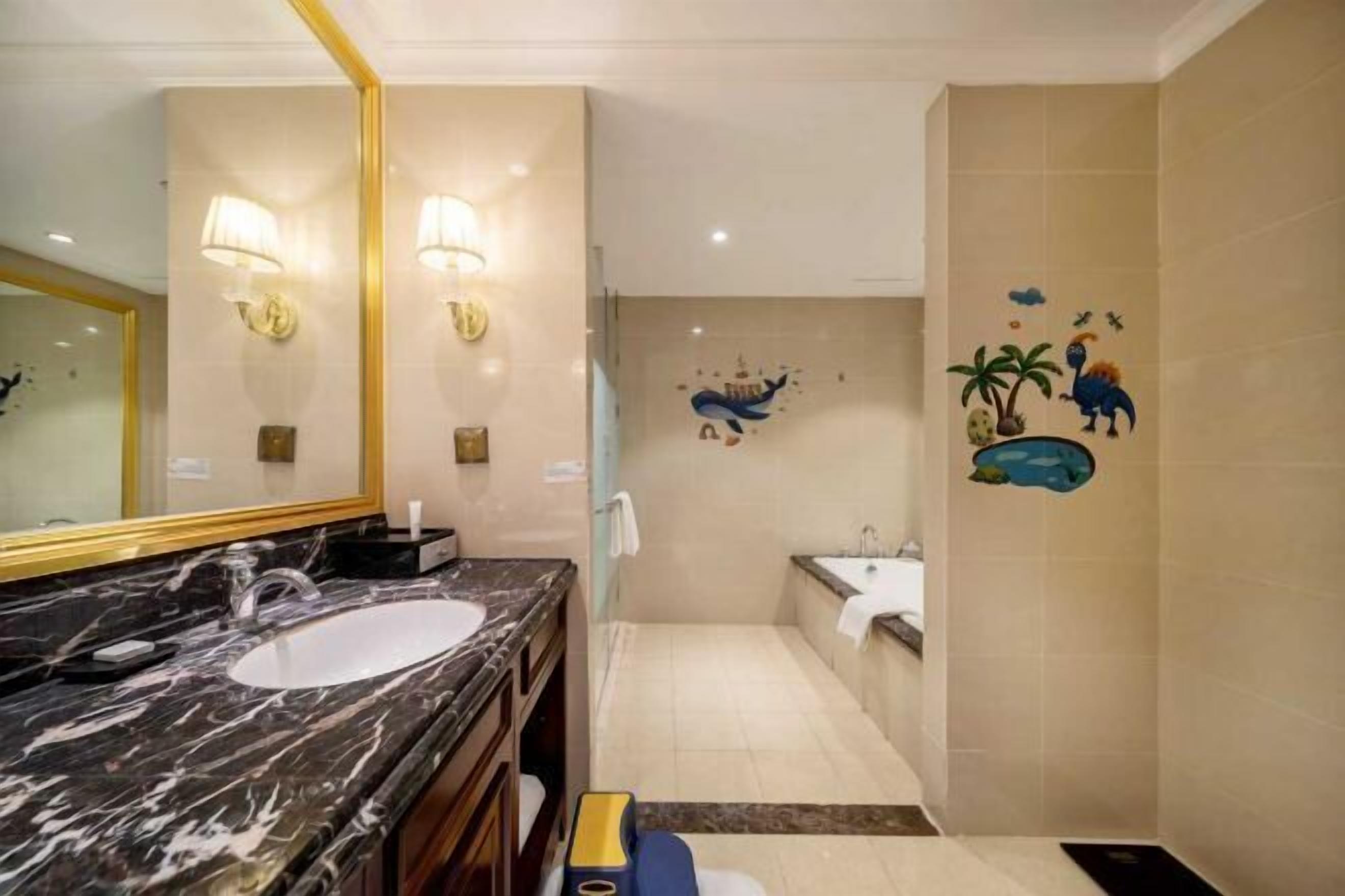 Un baño con lavamanos de mármol, bañera y ducha.