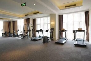 A hotel fitness center with treadmills, elliptical machines, and weight equipment.