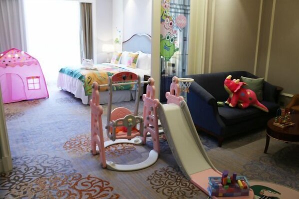 A hotel room with a bed, a play area with a slide, a pink playhouse, and a dark-colored sofa. - Howard Johnson Junhe Hotel Beijing (Beijing)