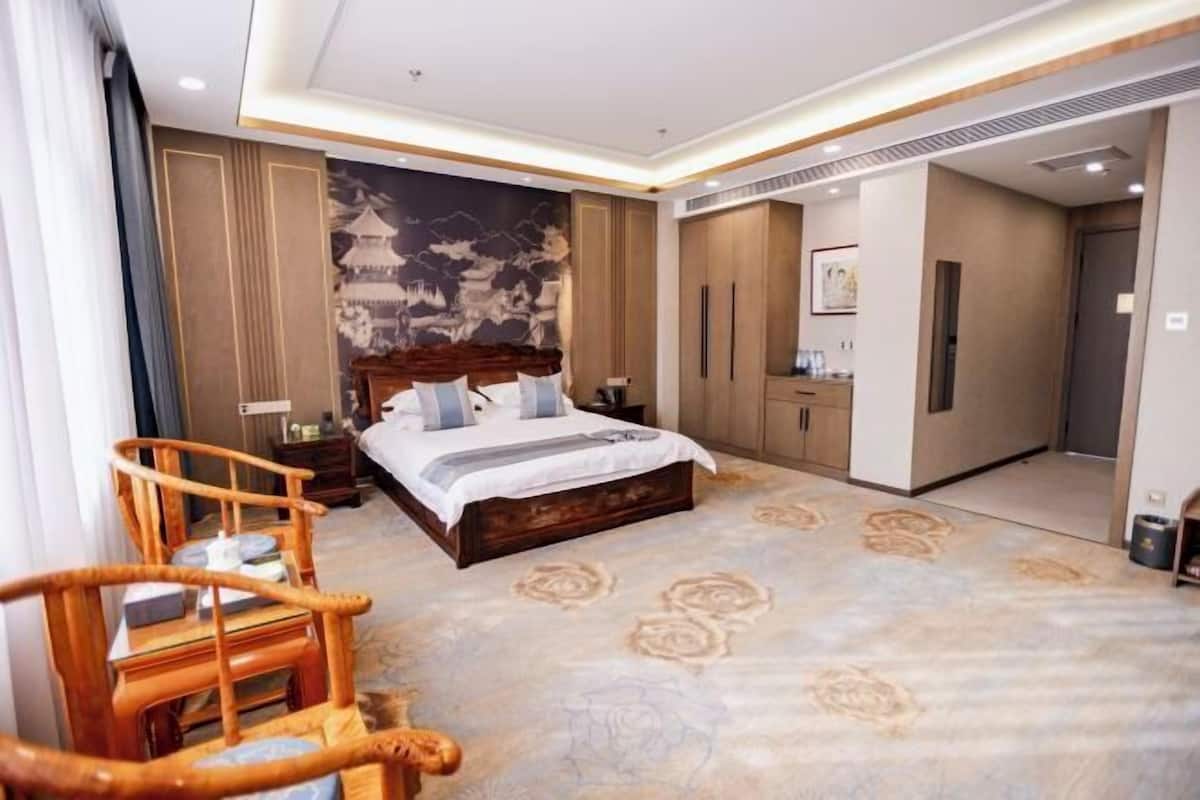 Una habitación de hotel con una cama, un armario de madera y una silla.