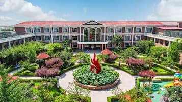 Un hotel con un patio central, una fuente y un parque infantil.