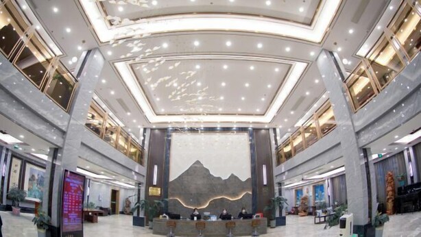 A spacious lobby with a central reception desk, large windows, and a modern ceiling design. - Villa Lido (Laiyang)