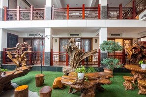 A multi-level indoor space with wooden furniture and plants, featuring a balcony with a railing. - Villa Lido (Laiyang)