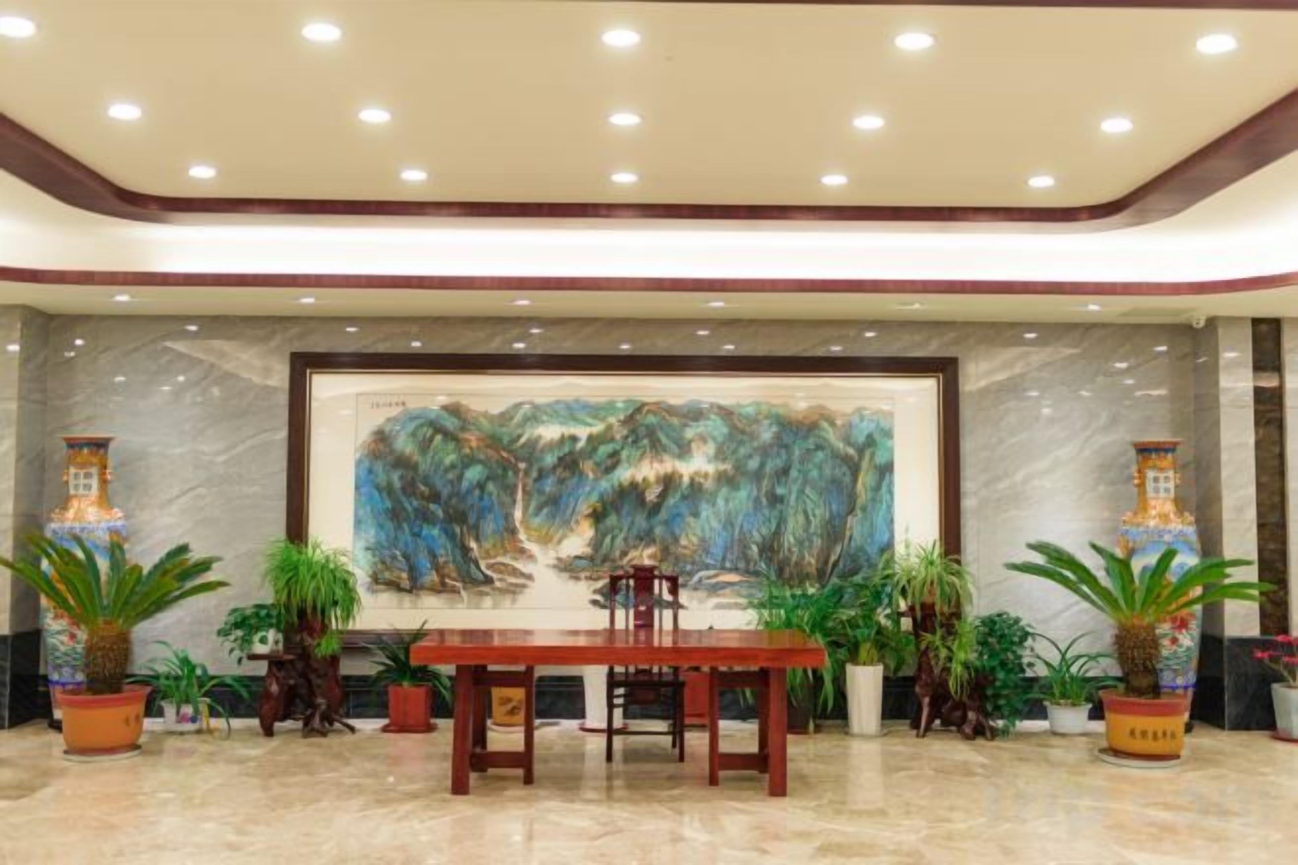 A lobby with a marble floor, a wooden reception desk, and a large abstract painting on the wall.