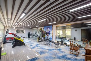 A gym with exercise equipment, mirrors, and a patterned floor. - Villa Lido (Laiyang)