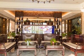 A lobby with seating, a fish tank, and decorative elements. - Villa Lido (Laiyang)