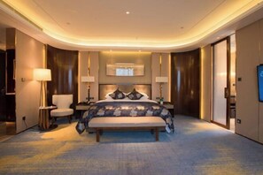 Una habitación de hotel moderna con una cama grande, lámparas de noche, un televisor de pantalla plana y un espejo grande sobre la cama.