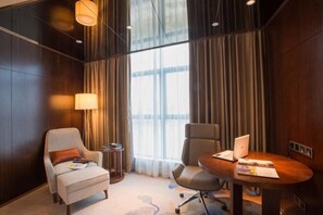 A conference room with a wooden table, two chairs, a laptop, and a lamp. - Phoenix Hotel (Wenshan City)