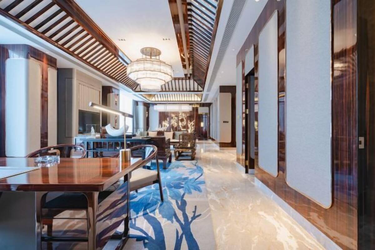 A modern interior with a long hallway, wooden furniture, and a patterned floor.