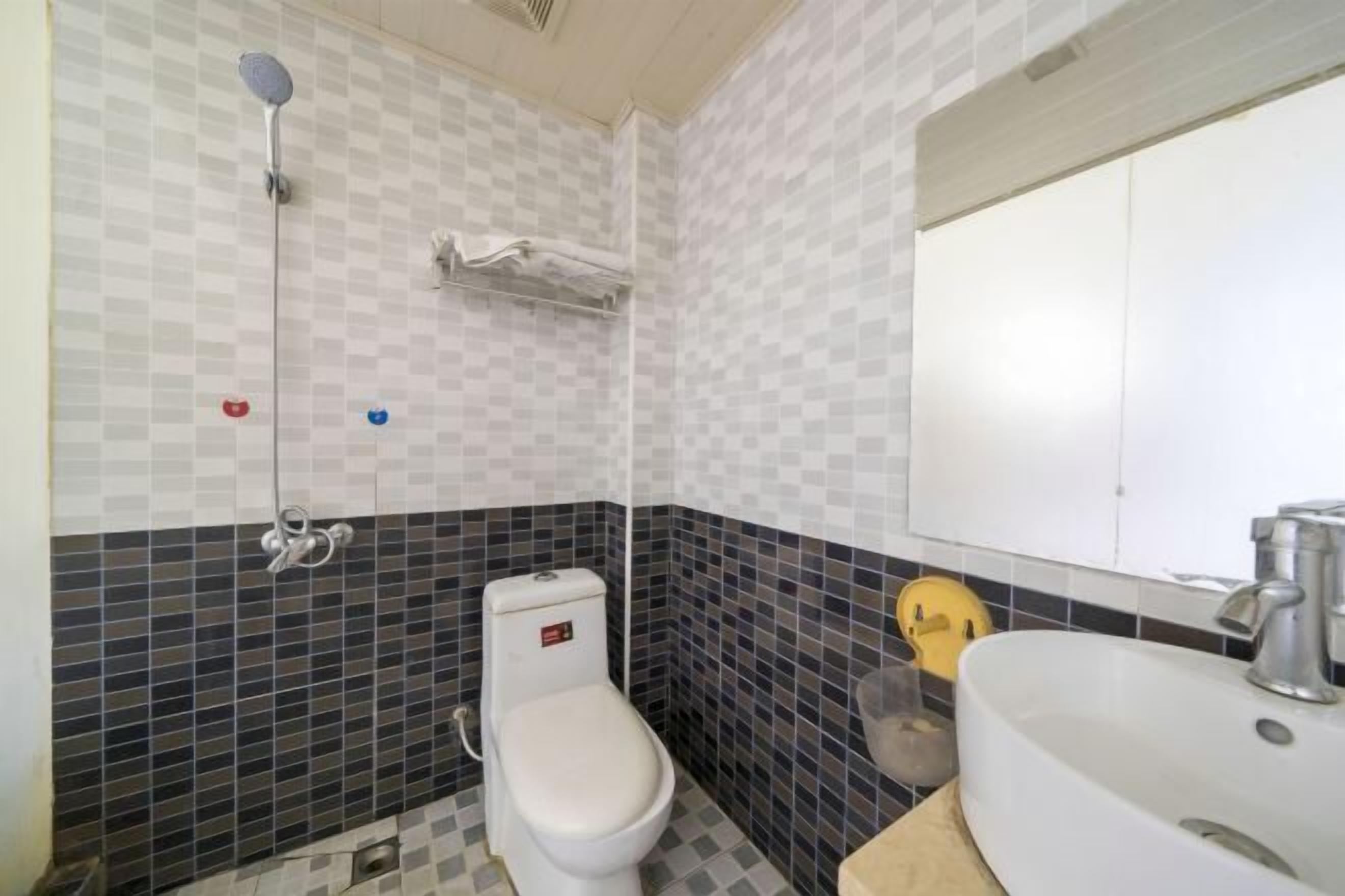 A bathroom with a toilet, a sink, and a shower.