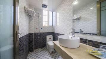 Un baño con un lavamanos blanco, un inodoro y una ducha.