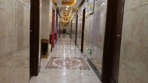 A hallway with marble floors and doors, leading to rooms. - Pingxiang IKEA Hotel Apartment (Pingxiang)