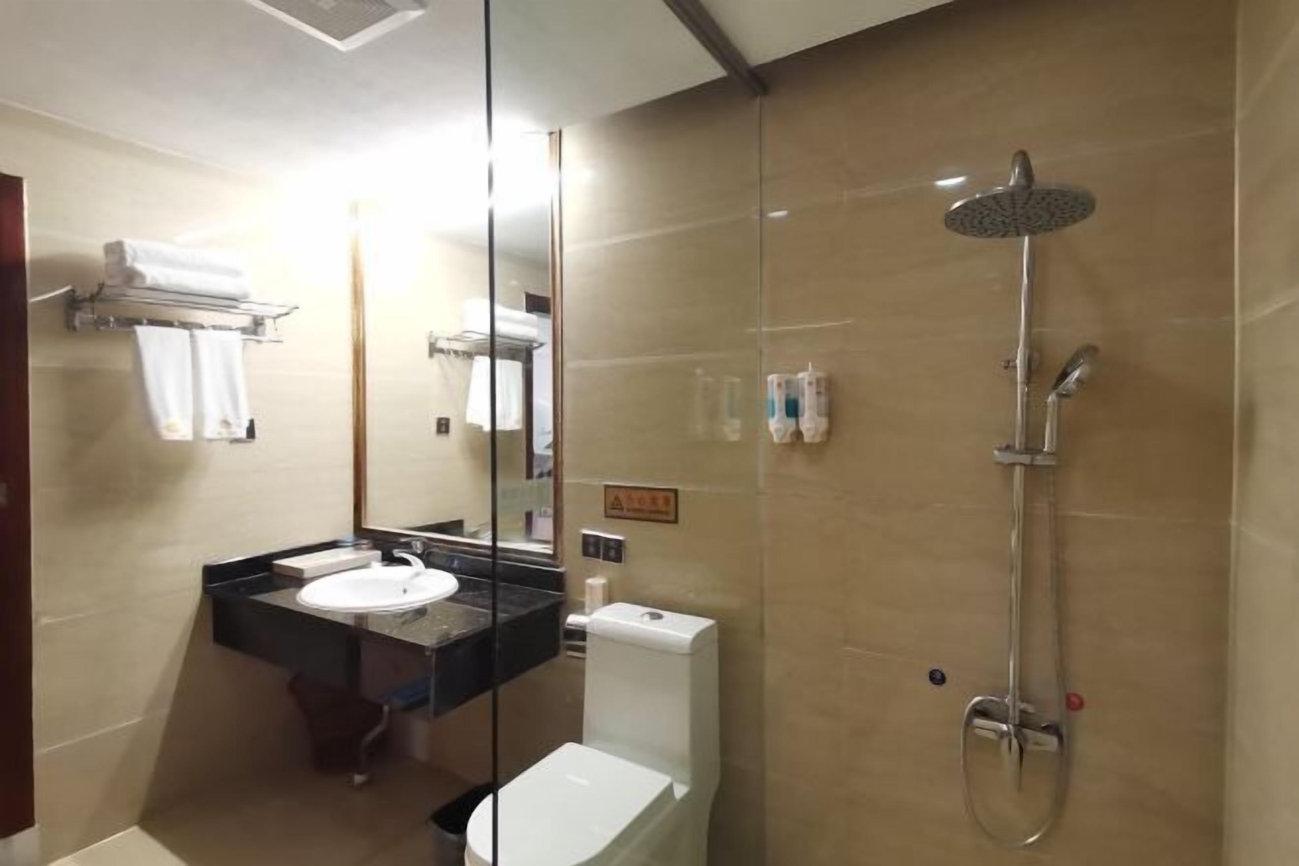 A bathroom with a glass-enclosed shower, a sink, and a toilet.