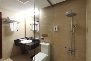 A bathroom with a glass-enclosed shower, a sink, and a toilet. - Wanmin International Hotel (Longlin)