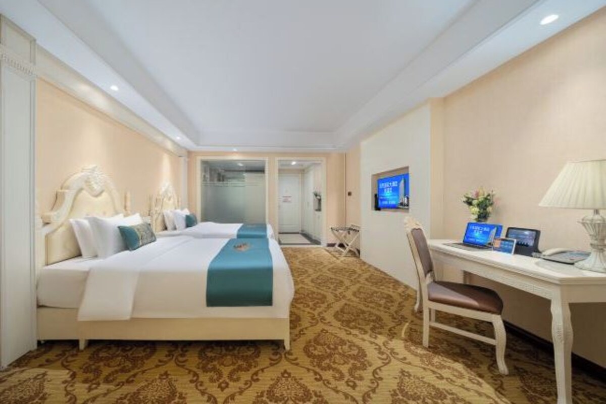 Habitación de hotel con cama doble, un escritorio con computadora y una silla.