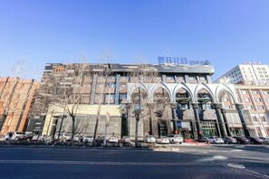 A multi-story building with a modern architectural design, featuring a prominent entrance with arched windows and a flat roof. - Roman Garden Business Center (Mudanjiang)