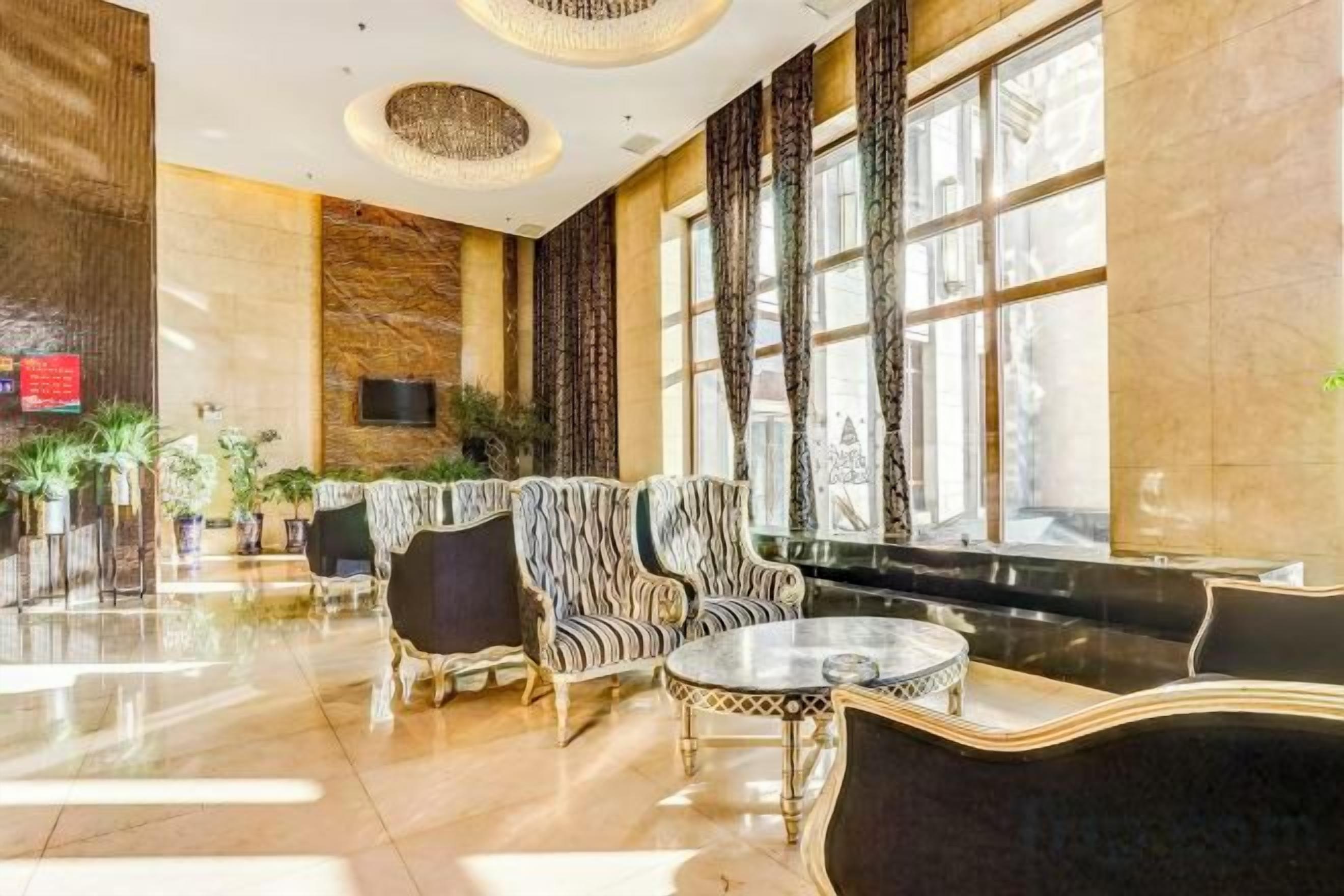 A spacious lobby with a reception desk, seating area, and large windows.