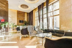 A spacious lobby with a reception desk, seating area, and large windows.