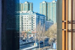 A view of a cityscape with tall buildings, a street, and bare trees. - Roman Garden Business Center (Mudanjiang)