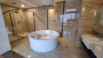 A modern bathroom with a freestanding bathtub, a glass-enclosed shower, and a separate sink area.