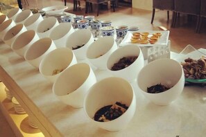 A buffet table with multiple white bowls containing various dishes. - Roman Garden Business Center (Mudanjiang)