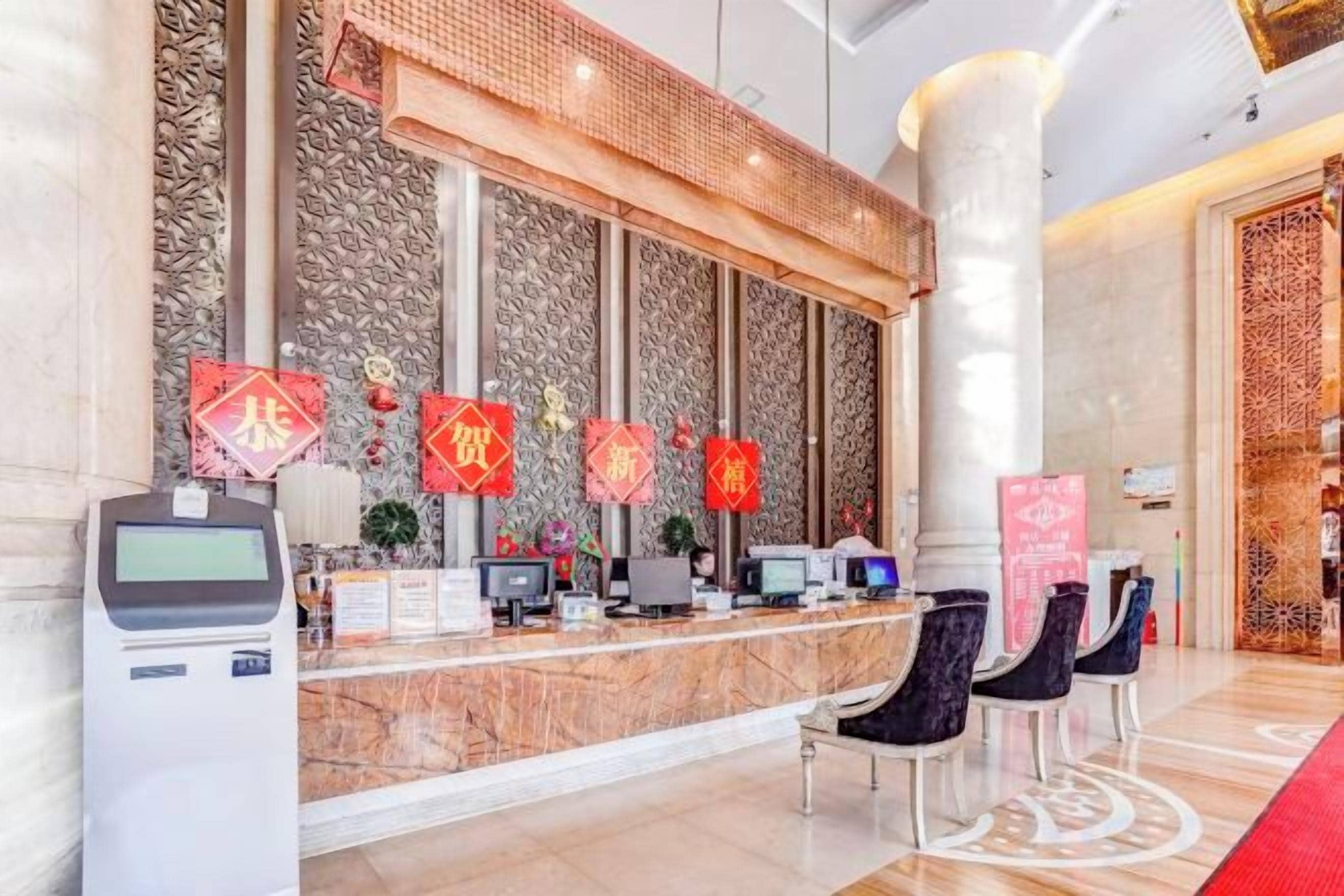 A reception area with a marble counter, several computer monitors, and a digital kiosk.