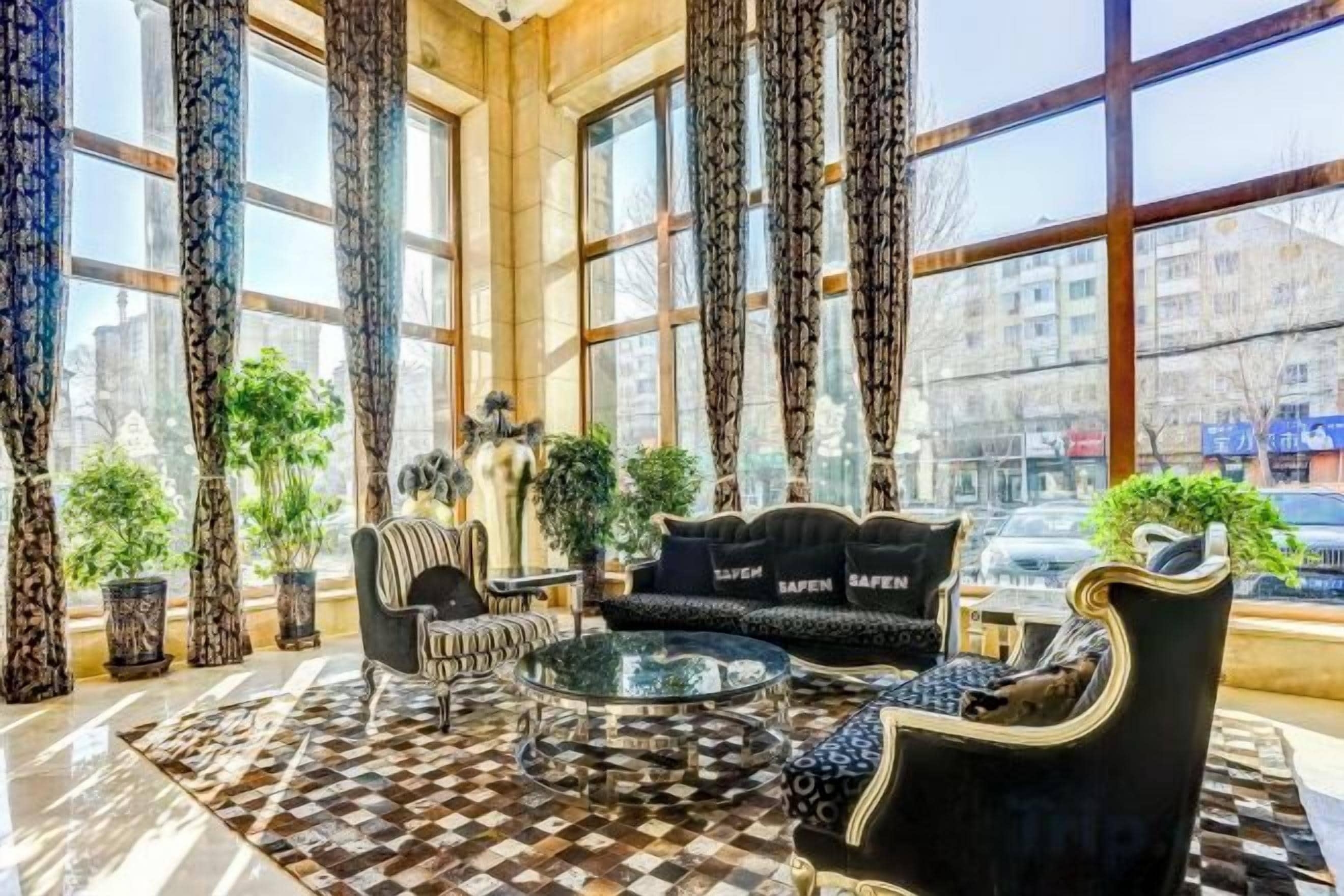 Um hall com piso xadrez, um sofá, uma poltrona e uma mesa de centro.