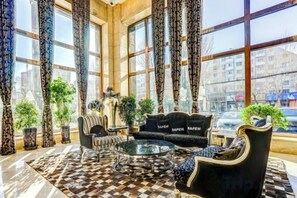 A lobby with a checkered floor, a sofa, a chair, and a coffee table. - Roman Garden Business Center (Mudanjiang)