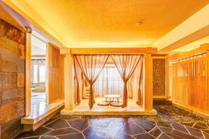 A room with a stone floor, a swing chair, and a view through a window with curtains. - Roman Garden Business Center (Mudanjiang)