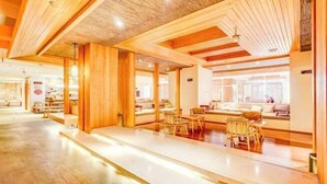 A spacious hotel lobby with wooden paneling, a reception desk, and seating areas. - Roman Garden Business Center (Mudanjiang)